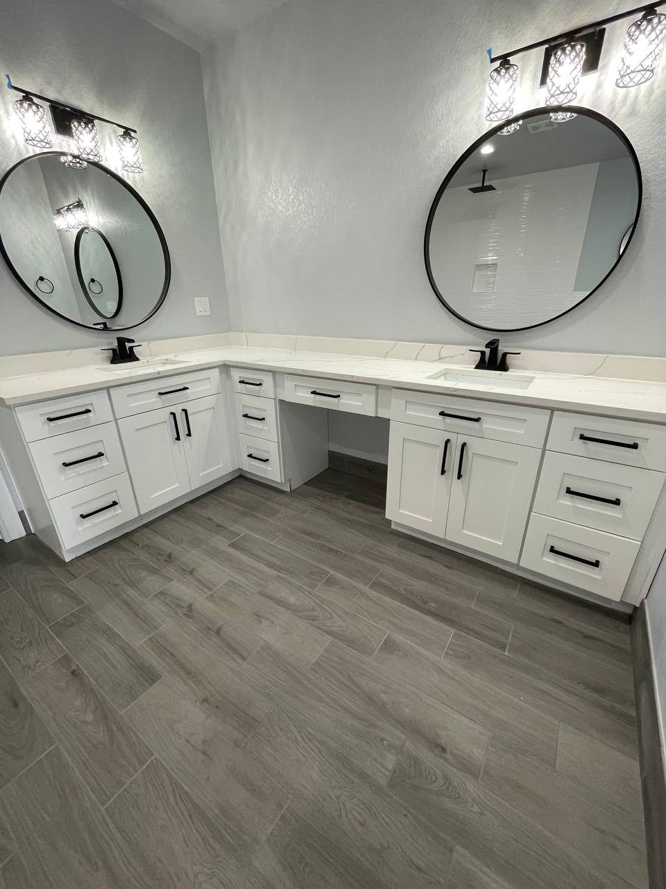 White L-shaped vanity with round mirrors
