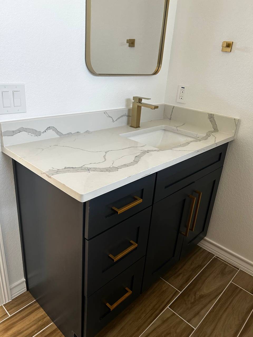 Navy vanity with gold hardware and quartz top