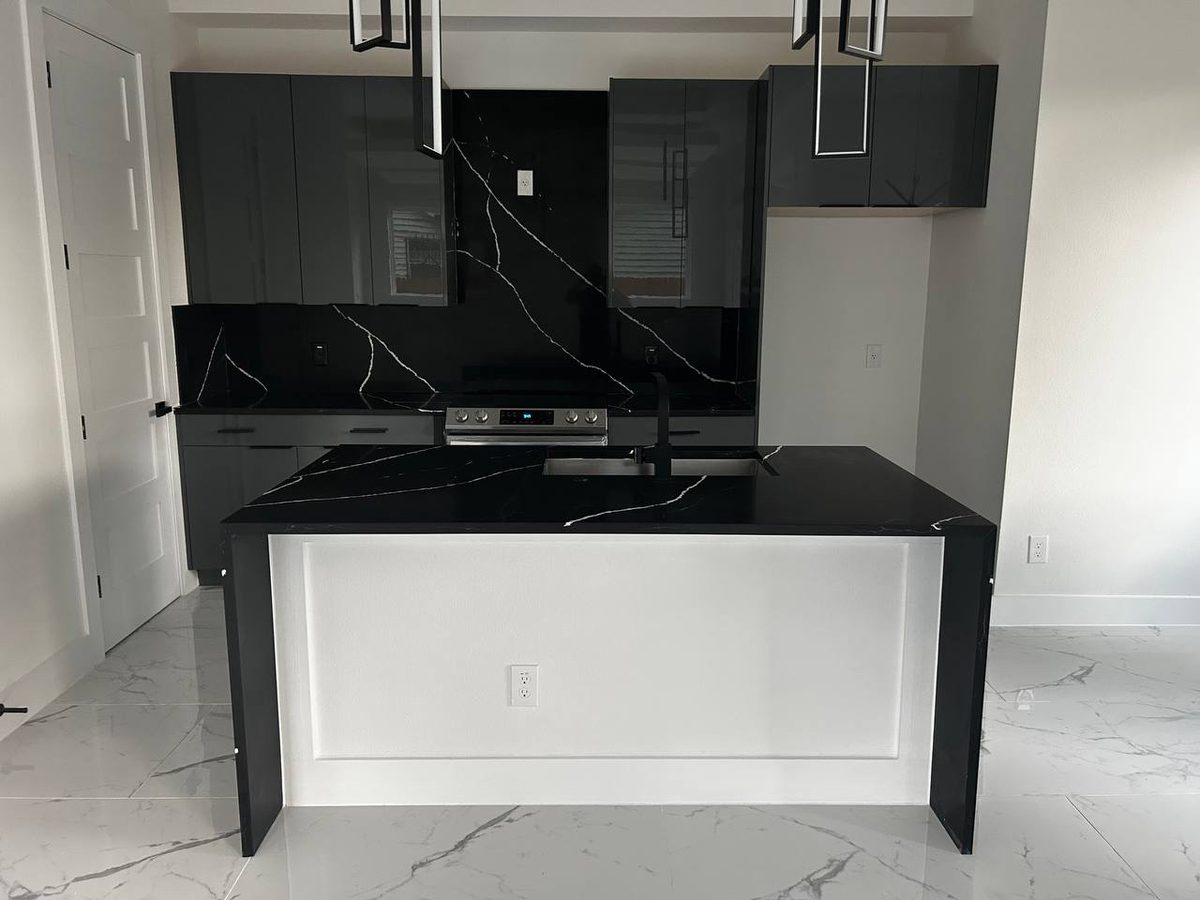 Kitchen with black marble waterfall island