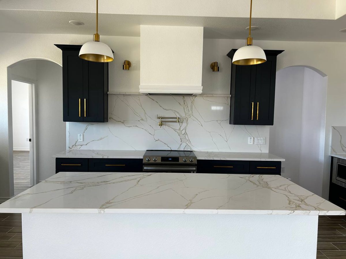 Navy kitchen with white hood and Calacatta island